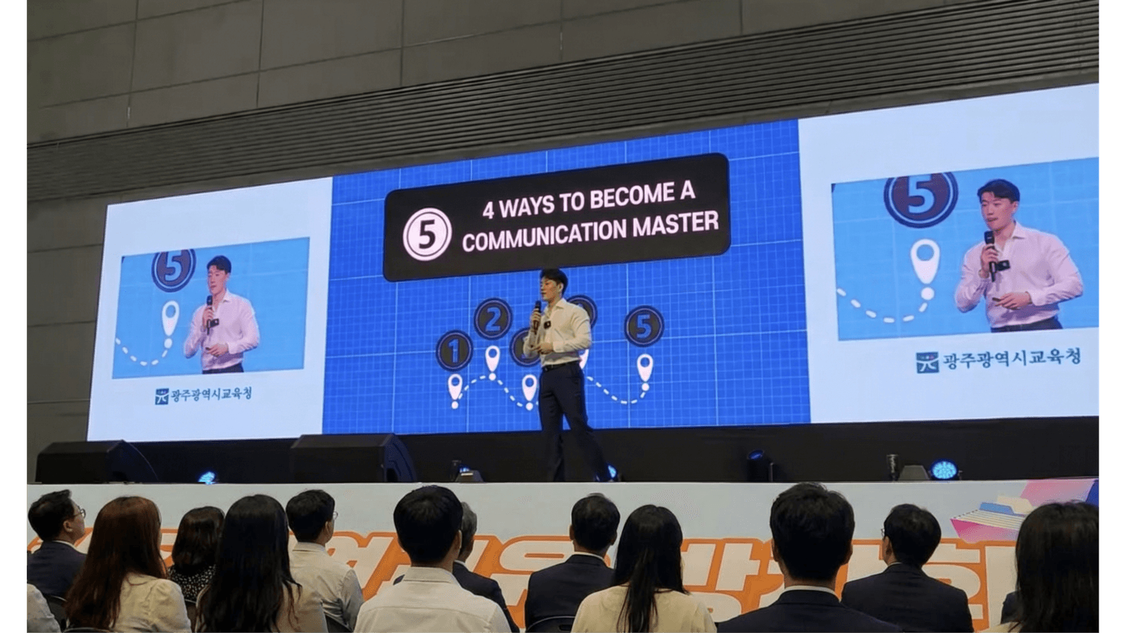 Jason Koh on stage with a microphone addressing an audience